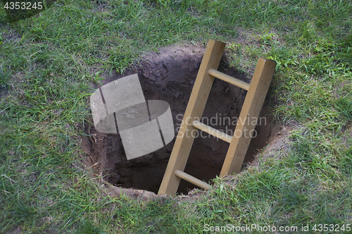 Image of Ladder coming out of a hole in the ground 