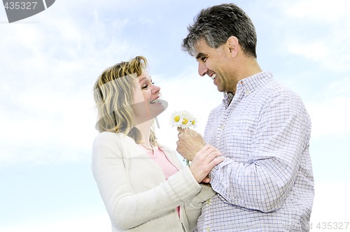 Image of Mature romantic couple with flowers