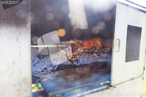 Image of Traditional balkan dish - whole piglet grilled on the open fire.