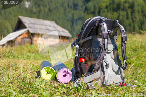 Image of Backpack and yoga mats on mountain meadow.