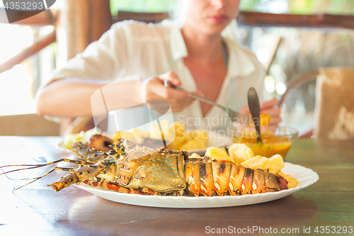 Image of Grilled lobster served with potatoes and coconut sauce.