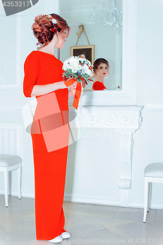 Image of Woman In Red Against A Mirror