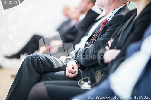 Image of Row of business people sitting at seminar.