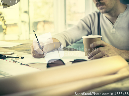 Image of Architect working on drawing table in office