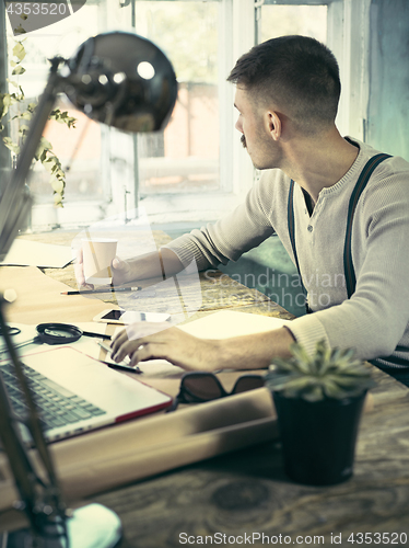 Image of Architect working on drawing table in office