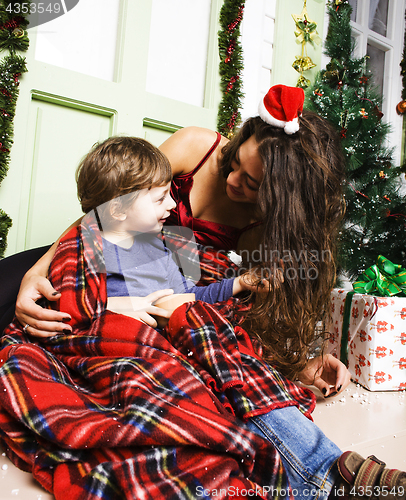 Image of happy smiling family on Christmas at house with gifts, young mot