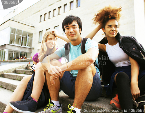 Image of cute group of teenages at the building of university with books 