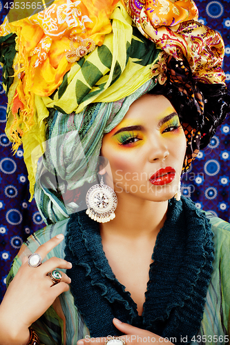 Image of beauty bright woman with creative make up, many shawls on head l