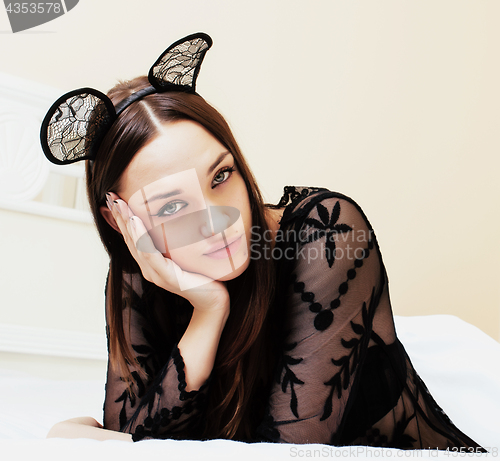 Image of young pretty brunette woman wearing sexy lace mouse ears, laying