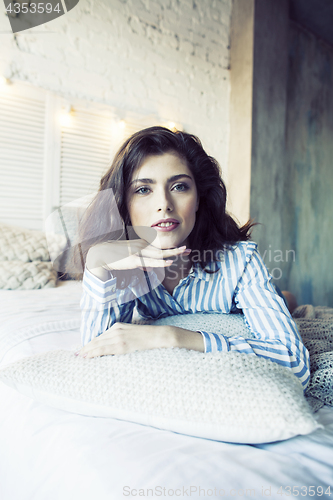 Image of young pretty brunette woman in her bedroom sitting at window, happy smiling lifestyle people concept 