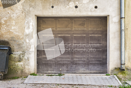 Image of Garage wooden door, dirty cracked wall background