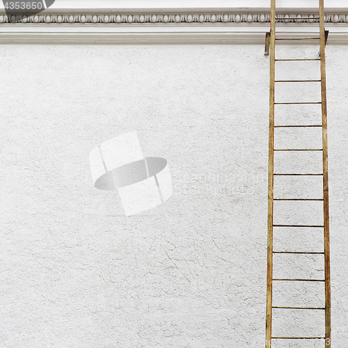 Image of White stucco wall with metal ladder