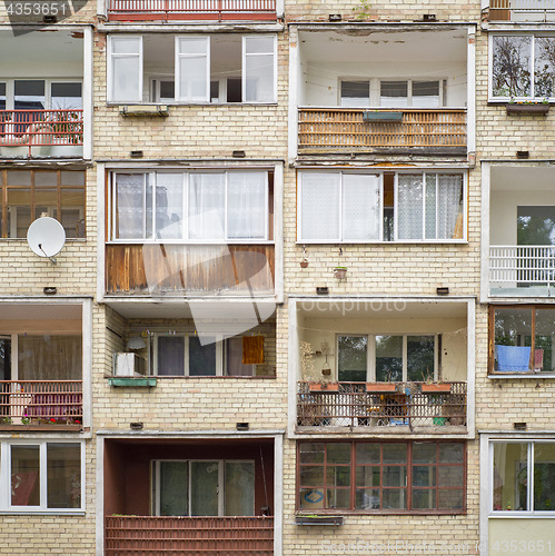 Image of Old building with balconies full of flowers, tables, chairs