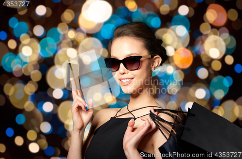 Image of happy woman with credit card and shopping bags