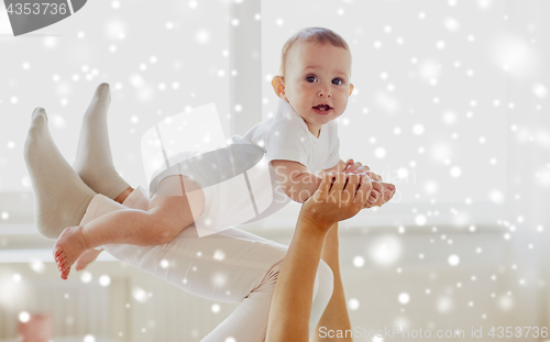 Image of happy mother playing with baby at home