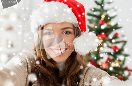 Image of woman in santa hat taking selfie at christmas