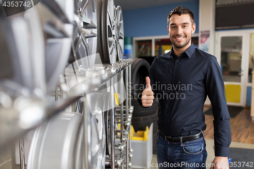Image of male customer choosing wheel rims at car service