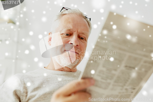 Image of close up of senior man reading newspaper at home