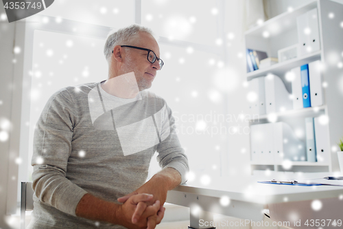 Image of senior man sitting at medical office table