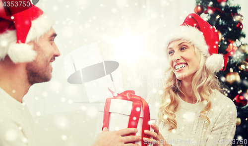 Image of happy couple at home with christmas gift box