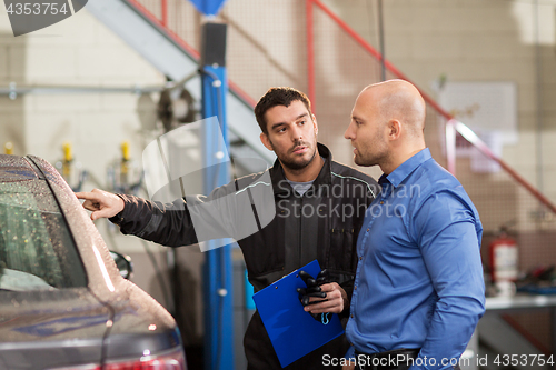 Image of auto mechanic and customer at car shop