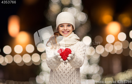 Image of happy girl in winter clothes with red heart