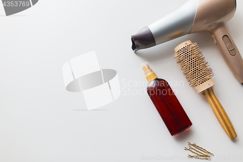 Image of hairdryer, brush, hot styling hair spray and pins