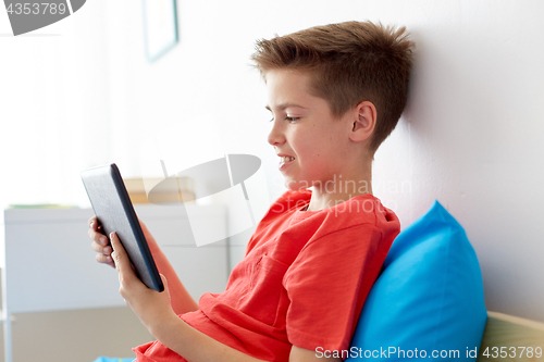 Image of smiling boy with tablet pc computer at home