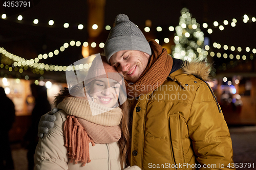 Image of happy couple hugging at christmas tree