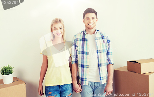 Image of smiling couple with big boxes moving to new home