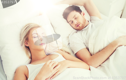 Image of happy couple sleeping in bed at home