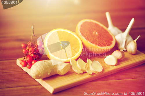 Image of citrus, ginger, garlic and rowanberry on wood