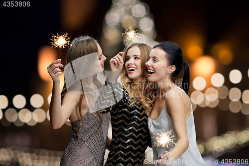 Image of happy young women with sparklers at new year night