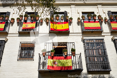 Image of The national flag of Spain hang on the balcony in a street