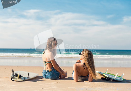 Image of Two surfer girls at the beach