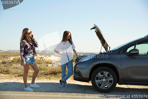 Image of Girls with a broken a car on country road