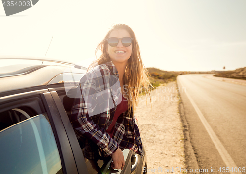 Image of happy girl looking out the car window