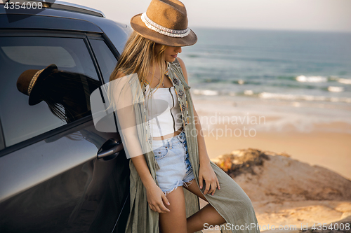 Image of Beautiful girl leaning over the car