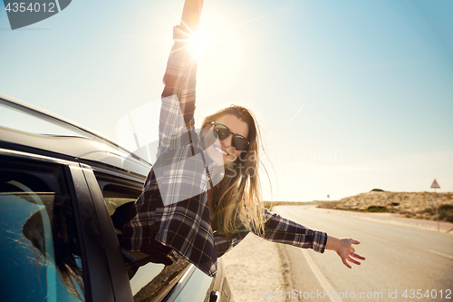 Image of happy girl looking out the car window