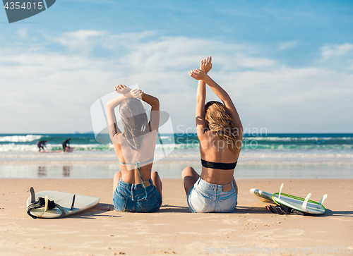 Image of Two surfer girls at the beach