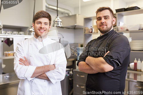 Image of happy smiling chef and cook at restaurant kitchen