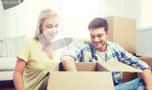 Image of smiling couple with big boxes moving to new home