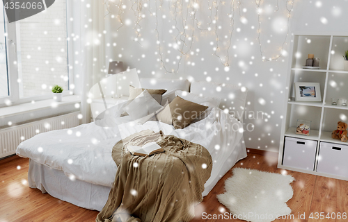 Image of bedroom with bed and christmas garland at home