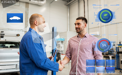 Image of auto mechanic and man shaking hands at car shop