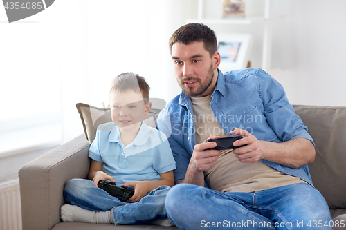 Image of father and son playing video game at home