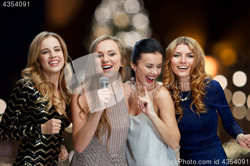 Image of women with microphone singing karaoke at christmas