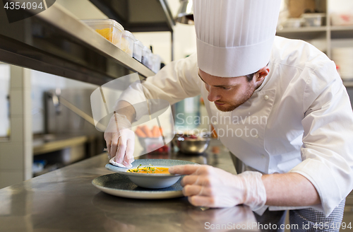 Image of happy male chef cooking food at restaurant kitchen