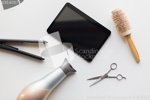 Image of tablet pc, scissors, hairdryer, hot iron and brush