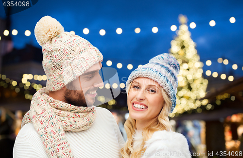 Image of happy couple over christmas tree lights