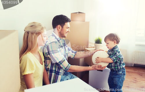 Image of happy family moving to new home and playing ball